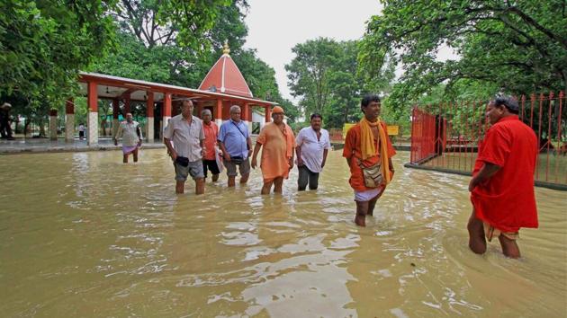 Devotees and a priest wade through floodwaters of Kopai river near a half-submerged Kankali Kali Temple in Birbhum district on Saturday. (PTI) Devotees and a priest wade through floodwaters of Kopai river near a half-submerged Kankali Kali Temple in Birbhum district on Saturday. (PTI)