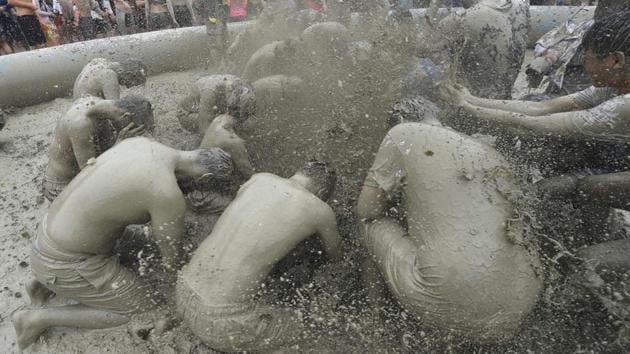 Tourists play with mud in a mud pool. The event drew roughly four million people last year, including 430,000 foreigners. The festival is estimated to have provided a regional economic impact worth 73 billion won ($65.3 million) last year. (JUNG Yeon-Je / AFP) 