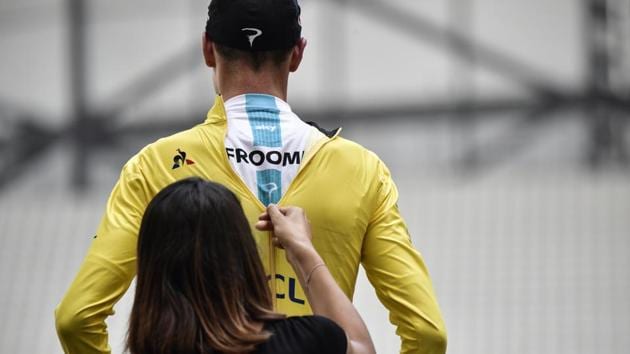 A hostess zips up the overall leader yellow jersey on Great Britain's Christopher Froome celebrating on the podium at the end of a 22,5 km individual time-trial, the twentieth stage of the 104th edition of the Tour de France cycling race on July 22, 2017 in and around Marseille, southern France. (Jeff PACHOUD / AFP) A hostess zips up the overall leader yellow jersey on Great Britain's Christopher Froome celebrating on the podium at the end of a 22,5 km individual time-trial, the twentieth stage of the 104th edition of the Tour de France cycling race on July 22, 2017 in and around Marseille, southern France. (Jeff PACHOUD / AFP)