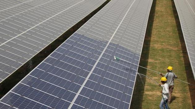 File photo of workers cleaning photovoltaic panels inside a solar power plant in Gujarat. (Reuters) File photo of workers cleaning photovoltaic panels inside a solar power plant in Gujarat. (Reuters)