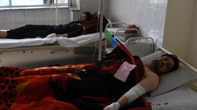 Afghan men rest in a hospital after being injured in a car bomb attack in Kabul. (SHAH MARAI / AFP)
