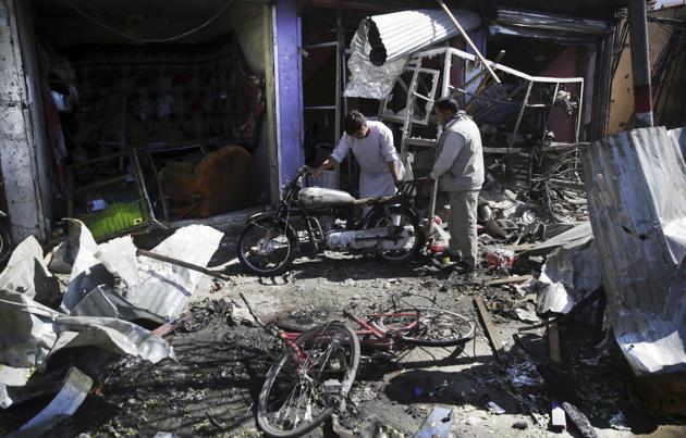 Men look at the remains of their properties at the site of a suicide attack in Kabul, Afghanistan, Monday, July 24, 2017. The Taliban have killed at least 24 people and wounded dozens more in a suicide bomb attack against a bus carrying government employees in the Afghan capital, Kabul. (Massoud Hossaini / AP)