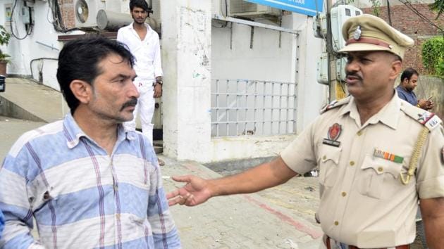 Police questioning petrol pumemployee Narain Dass outside an SBI branch in amritsar on Monday. (Sameer Sehgal /HT) Police questioning petrol pumemployee Narain Dass outside an SBI branch in amritsar on Monday. (Sameer Sehgal /HT)