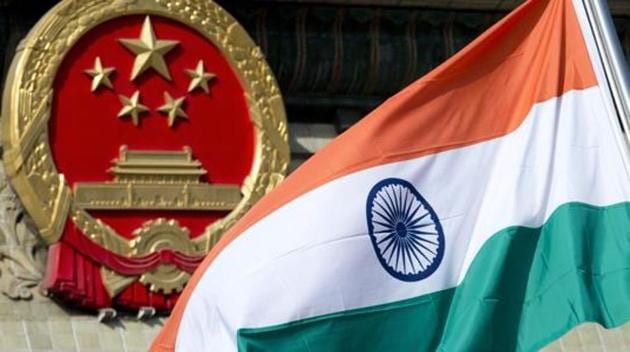 An Indian national flag is flown next to the Chinese national emblem during a welcome ceremony for visiting Indian officials outside the Great Hall of the People in Beijing. India says it is ready to hold talks with China with both sides pulling back their forces to end a standoff along a disputed territory high in the Himalayan mountains.(AP File Photo)