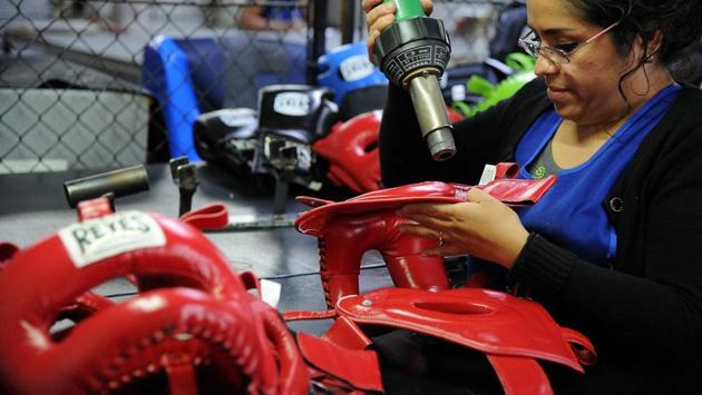 A staffer at Reyes Industries finishes work on protective training headgear. The company exports close to 70% of its gloves out of Mexico across five different continents. (Bernardo Montoya / AFP) A staffer at Reyes Industries finishes work on protective training headgear. The company exports close to 70% of its gloves out of Mexico across five different continents. (Bernardo Montoya / AFP)