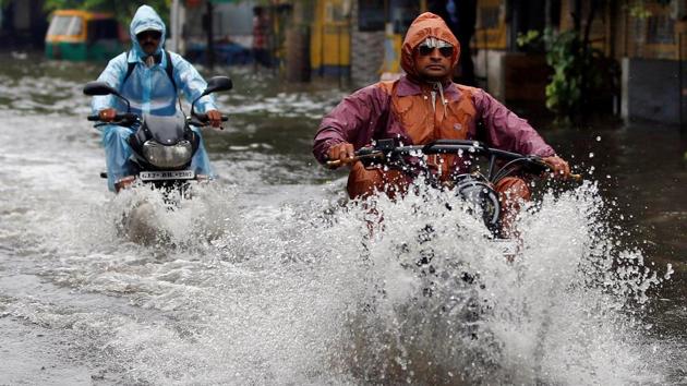 People drive through a flooded road after heavy rains in Ahmedabad. (Amit Dave / REUTERS) People drive through a flooded road after heavy rains in Ahmedabad. (Amit Dave / REUTERS)