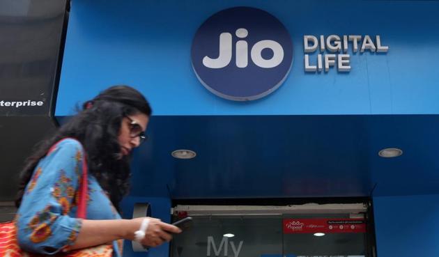 A woman checks her mobile phone as she walks past a mobile store of Reliance Industries' Jio telecoms unit, in Mumbai.(REUTERS)