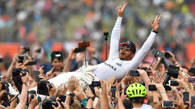 Mercedes' British driver Lewis Hamilton is celebrated by fans after the British Formula One Grand Prix at the Silverstone motor racing circuit in England on July 16, 2017.(AFP)