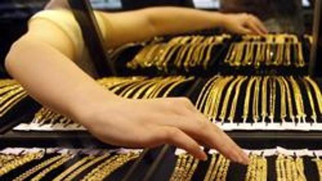 An employee arranges gold jewellery in the counter at a gold shop. The government has raised the investment limit for its gold bond scheme which was introduced in November 2015. (Reuters File Photo)