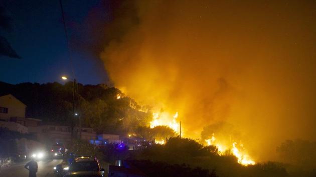 Firefighters work to stop a forest fire on a hillside near the village of Ortale, Corsica island, France. (AP Photo) Firefighters work to stop a forest fire on a hillside near the village of Ortale, Corsica island, France. (AP Photo)