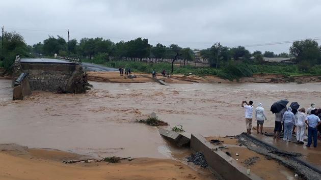 This photo taken on July 25, 2017 shows people gathering next to a washed away road in Deesa municipality, which has been hit by severe flooding along the Banas River in northern Gujarat state. (AFP Photo) This photo taken on July 25, 2017 shows people gathering next to a washed away road in Deesa municipality, which has been hit by severe flooding along the Banas River in northern Gujarat state. (AFP Photo)