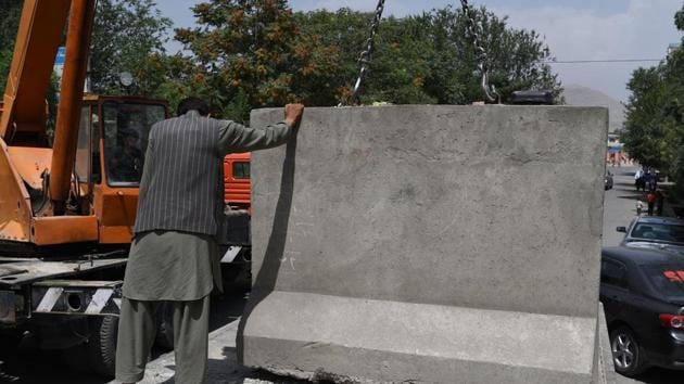 An Afghan government worker removes blast walls in Kabul. The blast walls that cut through Kabul like ramparts are being pulled down, part of a counter-intuitive makeover by local officials who argue the move will give the city's war-weary residents a psychological boost.(AFP Photo) An Afghan government worker removes blast walls in Kabul. The blast walls that cut through Kabul like ramparts are being pulled down, part of a counter-intuitive makeover by local officials who argue the move will give the city's war-weary residents a psychological boost.(AFP Photo)