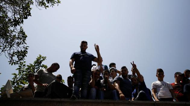 A Palestinian youth flashes a victory sign as others gather during prayers held outside the compound known to Muslims as Noble Sanctuary and to Jews as Temple Mount, just outside Jerusalem's Old City, on July 27, 2017. (Reuters)