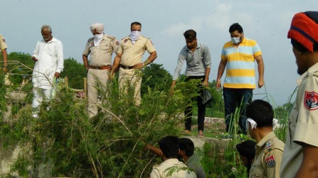 Police officials and villagers during the search operation at Kangna village in SBS Nagar on Wednesday.(HT Photo)