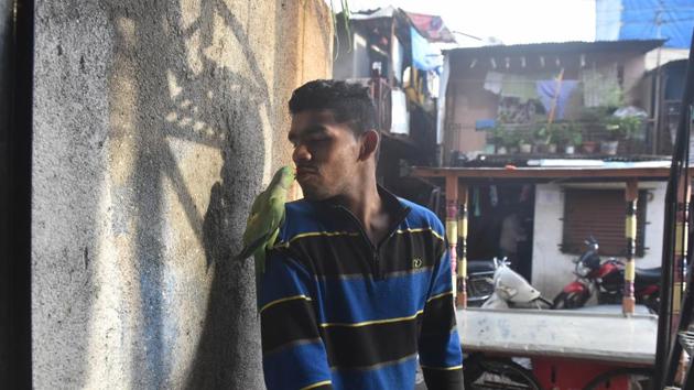 Akshay plays with his pet parrot outside his house at Dandekar bridge. (Pratham Gokhale/HT PHOTO) Akshay plays with his pet parrot outside his house at Dandekar bridge. (Pratham Gokhale/HT PHOTO)