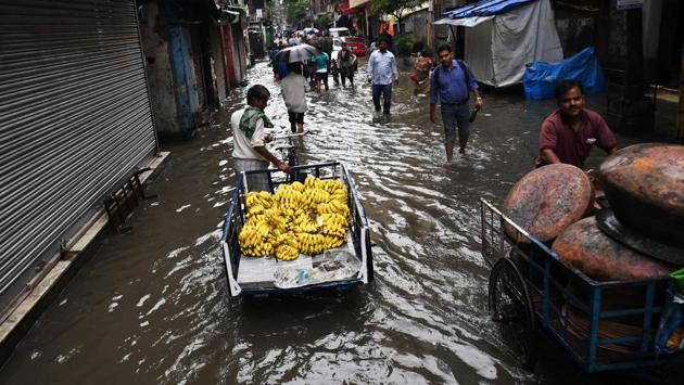 A cycle van puller transports bananas to the market through a water logged street in Kolkata. (Dibyangshu SARKAR / AFP)
