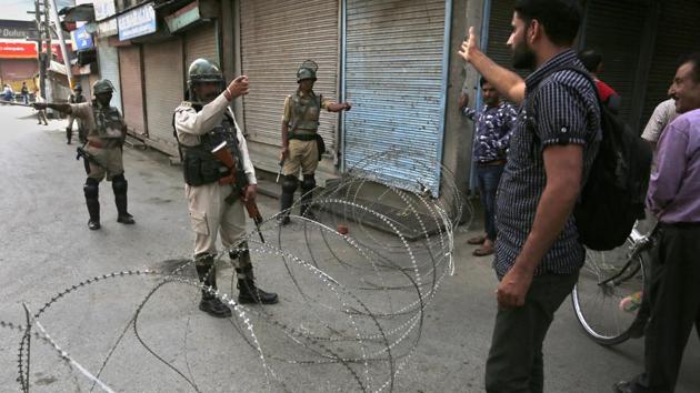 A Kashmiri man argues with a paramilitary soldier at the temporary checkpoint during restrictions in Srinagar on Friday.(AP)