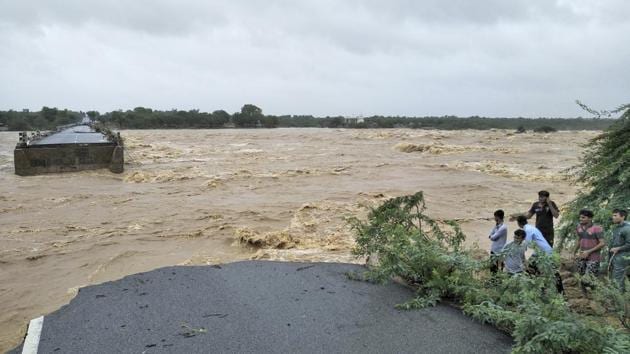People watch after a bridge on the Deesa Dhanera highway was washed away in monsoon floods in Gujarat. (AP)