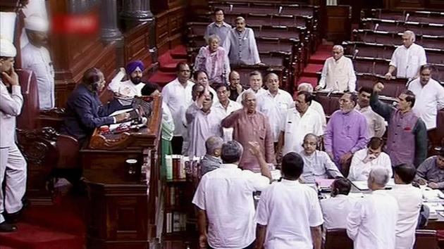 Opposition members protest in the well of Rajya Sabha in New Delhi on Friday.(PTI Photo)