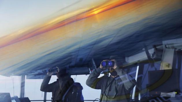 Researchers look toward the midnight sun while approaching the American island of Little Diomede, Alaska, and the Russian island of Big Diomede, as the Finnish icebreaker MSV Nordica sails along the international date line through the Bering Strait. The international date line is an imaginary border that runs through the middle of the Pacific Ocean and marks the boundary between calendar dates, effectively making it the zero-line for the planet’s time zones. (David Goldman / AP)
