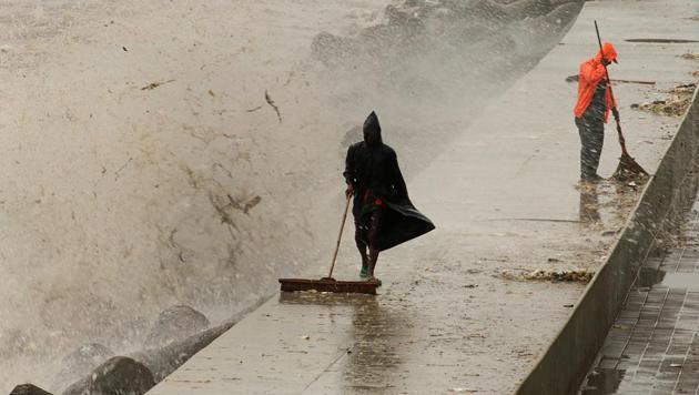 BMC employees clean waste material during high tide at Marine Drive in Mumbai on Wednesday, July 26. (Nilofer Khan/ HT) BMC employees clean waste material during high tide at Marine Drive in Mumbai on Wednesday, July 26. (Nilofer Khan/ HT)