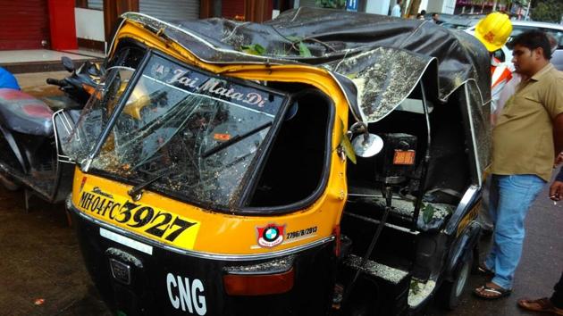 The autorickshaw that got damaged after the tree feel on it.(Praful Gangurde/HT Photo)