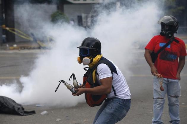 A demonstrator prepares Molotov cocktails as clashes break out while the Constituent Assembly election is being carried out in Caracas, Venezuela. (Reuters Photo) A demonstrator prepares Molotov cocktails as clashes break out while the Constituent Assembly election is being carried out in Caracas, Venezuela. (Reuters Photo)