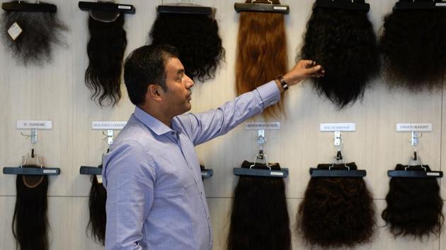 George B. Cherian, managing director of Raj Hair International, explains different hair products at the company's display centre in Chennai. While hair products manufactured from temple hair is often sold internationally, a part of the finished product also makes its way back into India, ironically branded as imported wig and extensions sourced and produced ‘ethically’. (Arun Sankar / AFP) George B. Cherian, managing director of Raj Hair International, explains different hair products at the company's display centre in Chennai. While hair products manufactured from temple hair is often sold internationally, a part of the finished product also makes its way back into India, ironically branded as imported wig and extensions sourced and produced ‘ethically’. (Arun Sankar / AFP)