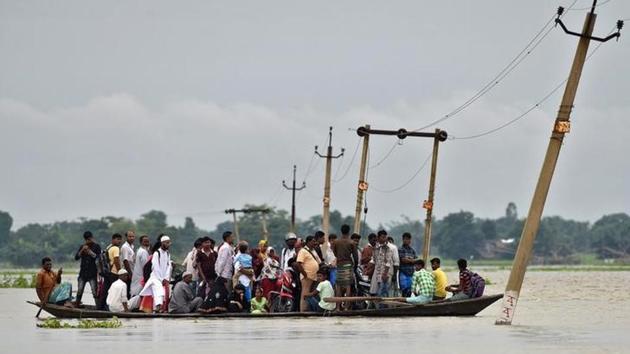 Villagers use a boat to cross a flooded road at Asigarh village in Morigaon district in the northeastern state of Assam.(Reuters File Photo)