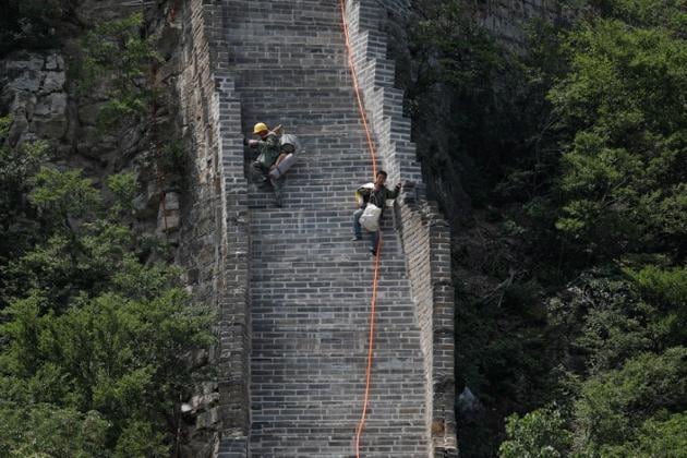 Workers carry their tools and belongings as they climb down the Jiankou section of the Great Wall, located in Huairou District, north of Beijing, China. (Reuters File Photo) Workers carry their tools and belongings as they climb down the Jiankou section of the Great Wall, located in Huairou District, north of Beijing, China. (Reuters File Photo)