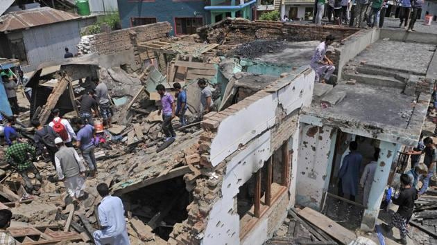 Villagers gather near the destroyed house where the militants were trapped in Hakripora in Kashmir’s Pulwama district on Tuesday, August 1. (Waseem Andrabi / HT Photo)