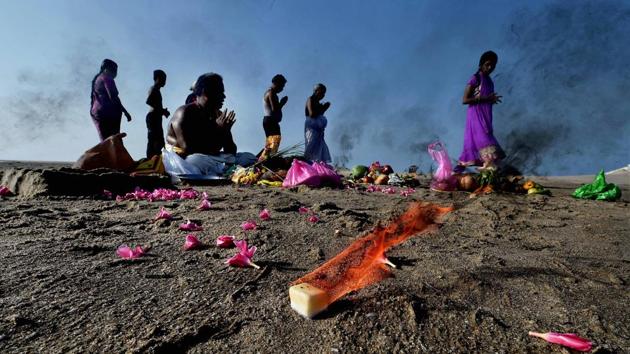 People offer prayers to their ancestors at the famous Dhanushkodi beach at Arichal Munai in Rameswaram. (R Senthil Kumar / PTI)