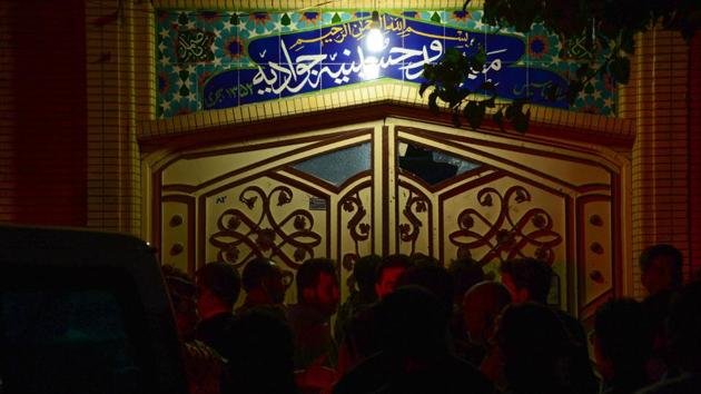 People gather on the street following a suicide bomb attack at a Shiite mosque. (Hoshang Hashimi / AFP)