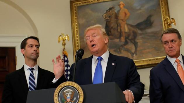 US President Donald Trump speaks during an announcement on immigration reform accompanied by Senator Tom Cotton (Left) and Senator David Perdue, at the White House on Wednesday.(REUTERS)