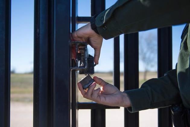 A US Border Patrol agent as he locks a gate on the border fence at the US/Mexico border in Del Rio, Texas on FEbruary 21, 2017.(AFP File Photo) A US Border Patrol agent as he locks a gate on the border fence at the US/Mexico border in Del Rio, Texas on FEbruary 21, 2017.(AFP File Photo)