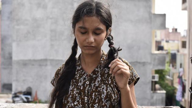 A girl shows her chopped braid in Mayapuri. The family claims that someone cut the hair of four women when they were asleep. Similar reports were received from Rohini and Pandav Nagar too.(Burhaan Kinu/HT PHOTO)