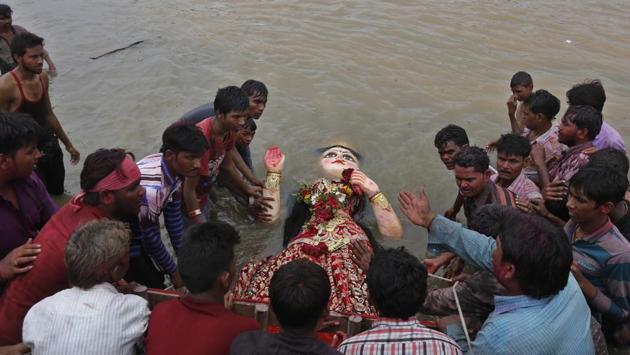 Devotees immerse an idol of Hindu goddess Dashama into the Sabarmati marking the end of Dashama festival in Ahmedabad. Once the fast is completed, the concerned family member undertakes the task of immersing the idol, as a sign of bidding farewell. (Ajit Solanki / AP)