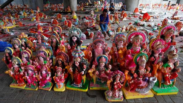 People sit amidst idols as they wait to load them onto a truck, a day after Dashama festival during which Hindu devotees keep idols of goddess Dashama in their houses for ten days before immersing or placing them near the banks of the Sabarmati river. The rituals involved in the festival and its associated period of fasting are supposed to aid prosperity and improve one’s destiny. (Amit Dave / REUTERS)