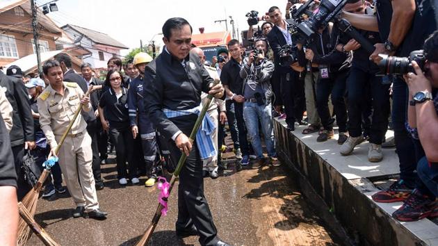 Thailand Prime Minister Prayut Chan-O-Cha using a ceremonial broom to help clean a street in a town in the province of Sakon Nakhon in northeastern Thailand, after it was hit by floods. (AFP photo) Thailand Prime Minister Prayut Chan-O-Cha using a ceremonial broom to help clean a street in a town in the province of Sakon Nakhon in northeastern Thailand, after it was hit by floods. (AFP photo)