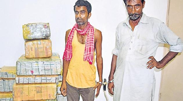 The arrested truck driver and cleaner with the seized contraband. (HT photo) The arrested truck driver and cleaner with the seized contraband. (HT photo)