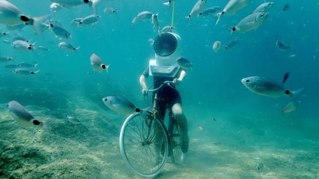A woman dives and pretends to ride a bike in Underwater Park in Pula, Croatia. (REUTERS)