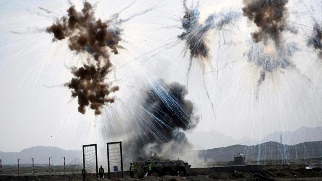 Chemical defense soldiers drive past a bombed position during Safe Environment competition, part of the International Army Games 2017 in Korla, Xinjiang Uighur Autonomous Region, China. (Wang Xiaojun / REUTERS)