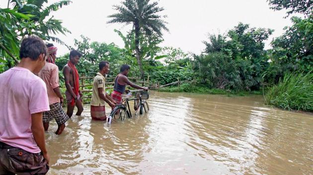 People wade through flood waters at Thiba Jalpara village in Birbhum district of West Bengal. (PTI Photo) People wade through flood waters at Thiba Jalpara village in Birbhum district of West Bengal. (PTI Photo)