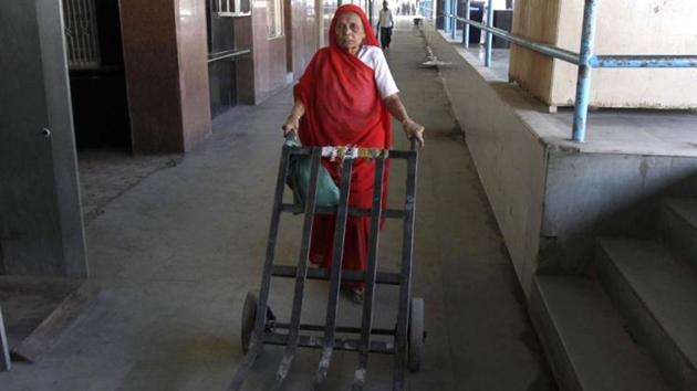 Hariben Matiya, an Indian woman who has been working for decades as a porter -- traditionally a man's job in India, pushes a trolley at the Bhavnagar railway station in Gujarat state.(AP File Photo)