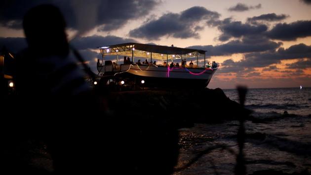 Palestinians are seen aboard ‘Lolo Rose’ ship which has become a popular restaurant, on a beach in Gaza City . (REUTERS)