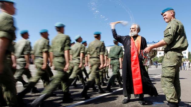 An Orthodox priest blesses Russian paratroopers marching during Paratroopers' Day celebrations, the annual holiday of Russian Airborne Troops, at their military unit in the southern city of Stavropol, Russia. (Eduard Korniyenko / REUTERS)