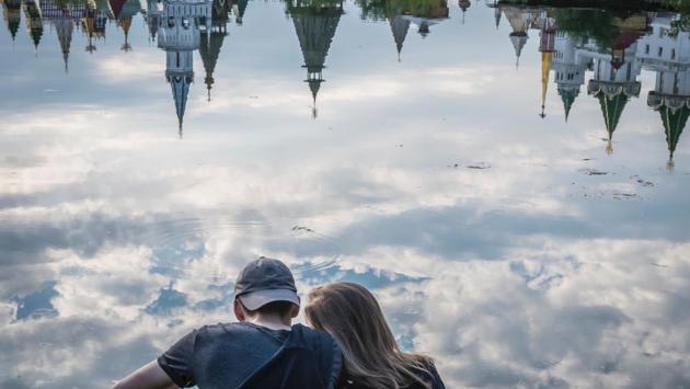 A couple enjoys the view of the ethnographic and amusement center Kremlin in Izmailovo reflected in the Serebryano-Vinogradnii lake in Moscow . (AFP)
