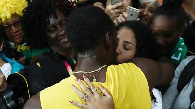 Usain Bolt with a Jamaican fan after the 100m race at the IAAF World Championships of Athletics on Saturday. (Getty Images)