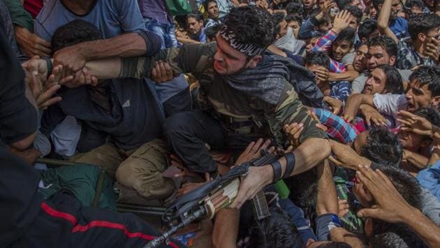 Villagers help a Kashmiri militant to climb on a stage as he appears at a funeral to pay tributes to slain rebel Suhail Ahmed, who was killed in an ambush by Indian government forces in Tantraypora, south of Srinagar. (Dar Yasin / AP) Villagers help a Kashmiri militant to climb on a stage as he appears at a funeral to pay tributes to slain rebel Suhail Ahmed, who was killed in an ambush by Indian government forces in Tantraypora, south of Srinagar. (Dar Yasin / AP)
