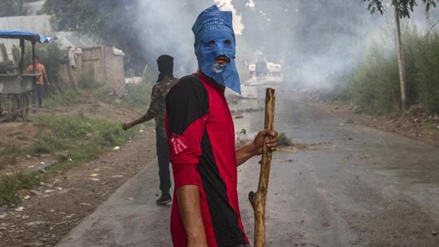 A masked villager holds a wooden stick and a stones during a protest following the funeral procession of Akeel Ahmed Bhat, a teenage boy in Haal village, about 47 Kilometers (29 miles) south of Srinagar. (Dar Yasin / AP) A masked villager holds a wooden stick and a stones during a protest following the funeral procession of Akeel Ahmed Bhat, a teenage boy in Haal village, about 47 Kilometers (29 miles) south of Srinagar. (Dar Yasin / AP)